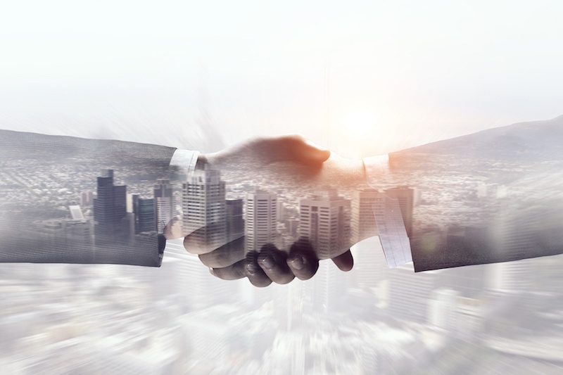 Shaking hands in front of building